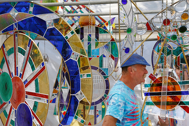 Bloomington leaded-glass artist Jacques Bachelier surrounded by a myriad of his colorful works. Photo by Peter Hamlin