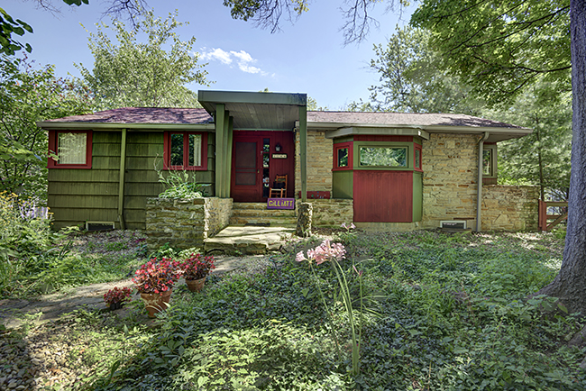 Lynne Gilliatt’s mid-century ranch in Elm Heights sits low amid trees and undergrowth. Photo by Kendall Reeves