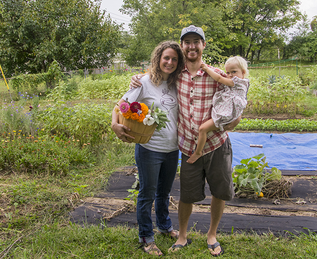 Michelle and Nate Dodson with daughter, Josephene, in their backyard garden plot on Bloomington’s northwest side. Photo by Darryl Smith