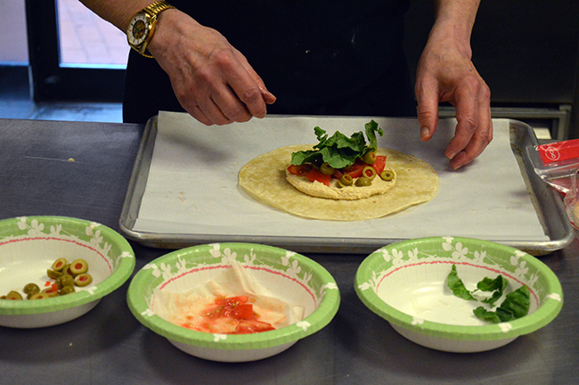 Preparation of a wrap, showing the suggested ratio of ingredients per tortilla. Photo by Erin Stephenson