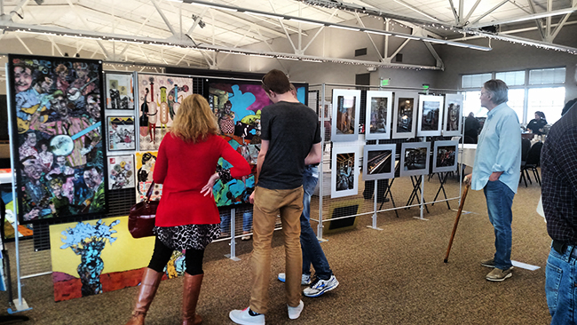 Showcase-goers examine artwork by Kevin Pope and Kendall Reeves. Photo by Erin Stephenson