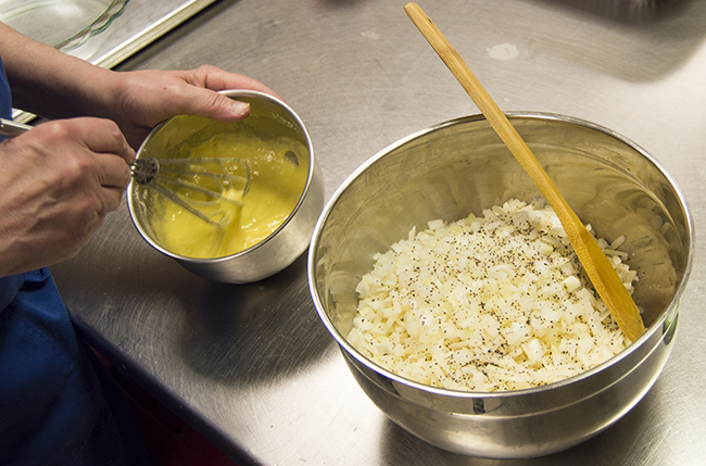 Mixing the eggs, flour, baking powder, and oil before adding to the shredded potato and onions. Photo by Erin Stephenson