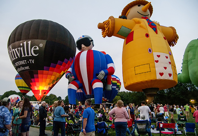 Hot air balloons begin to fill the Monroe County Fairgrounds Saturday evening as the sun began to set. Participating balloons returned or were retrieved from their flights to stand tall and light up their burners during live performances by Marc Broussard on Friday night and Jenn Cristy on Saturday.