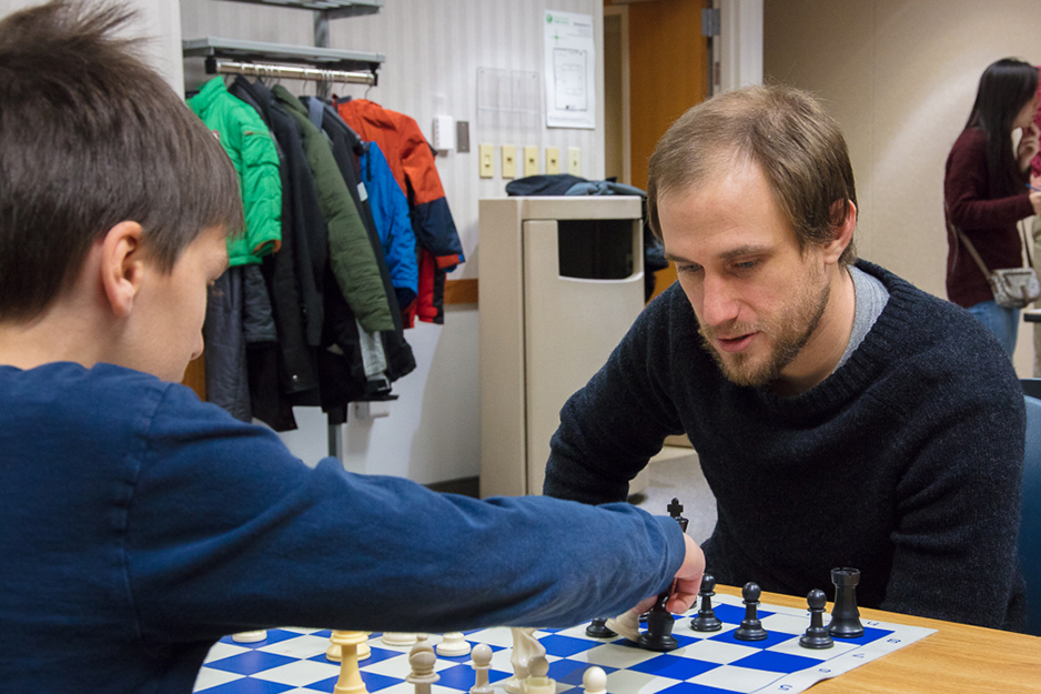 John Illg teaches strategy to a young chess club member. Photos by James Kellar