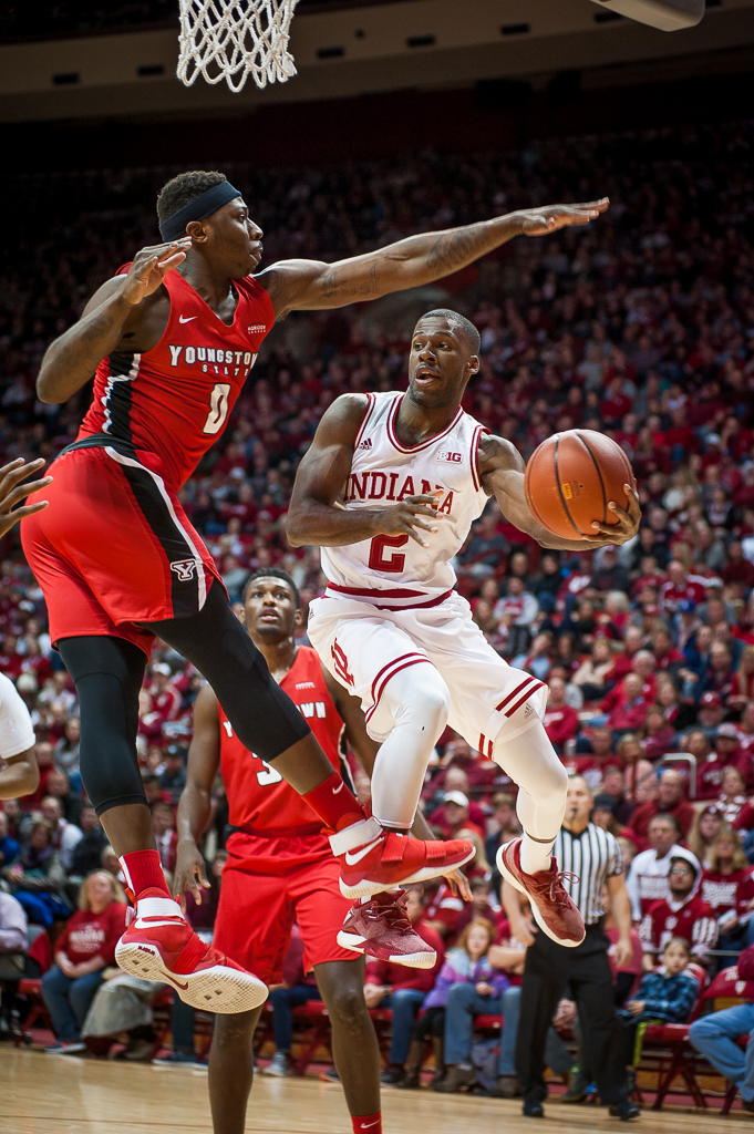 Indiana's Josh Newkirk, 2, drives and dishes off a pass beneath the attempted block by Youngstown State's Tyree Robinson in the first half of the Hoosiers' 79-51 win over the Penguins Friday night, December 29. Photo by Rodney Margison