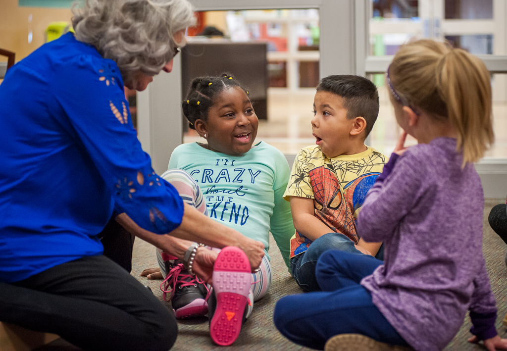 Kindergarten student Audriannia Fair gets help from Fairview Elementary School Principal Marti Colglazier as she tries on her new boots, while classmates Immanuel Duncan and Kendal Ray watch and await their turn. Photos by Rodney Margison