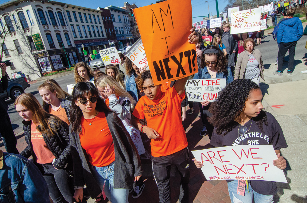 Caleb Poer (holding “Am I Next?” sign) marches with other high school students at the April 20 anti-gun rally in downtown Bloomington. Photos by Rodney Margison