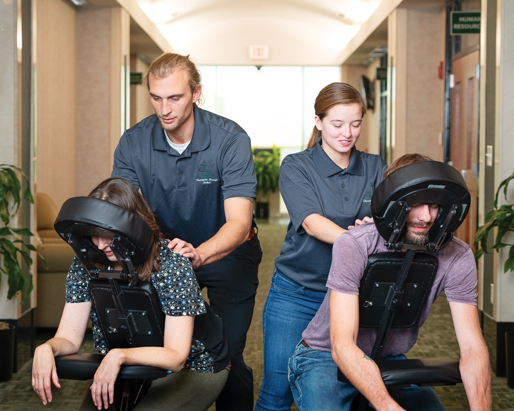 Ivy Tech massage therapy students Shawn Blankenship and Madison Sampson work with chair massage clients. Photo by Martin Boling