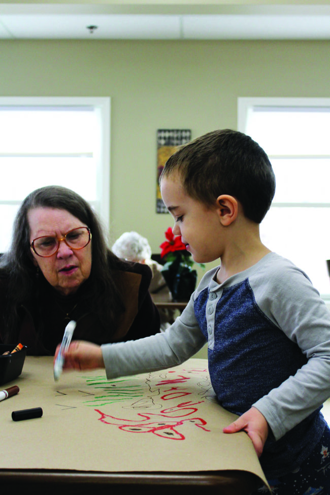 Daniel Thrasher shows Candy his drawing of trees and birds.