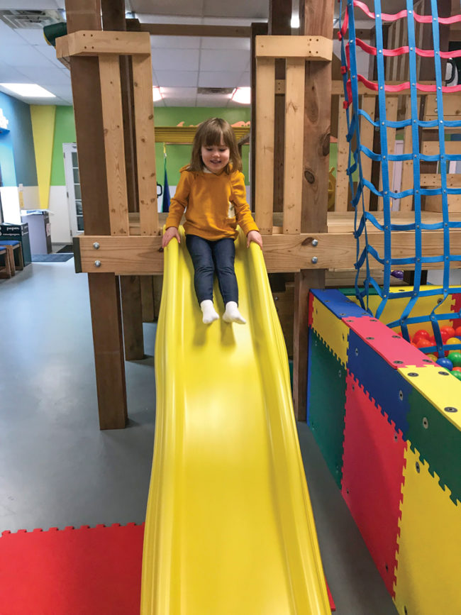 Claire Mansfield on the treehouse slide at Kids Play Gym. Photo by Jillian Davenport