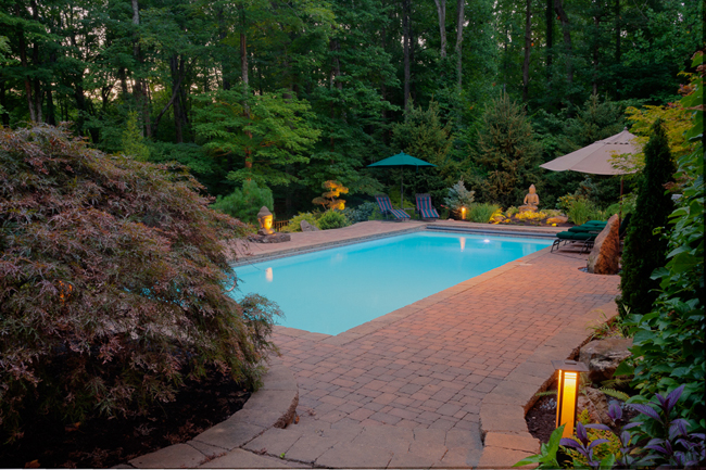 Ted and Soili Ochsner’s garden seems like a completely different place at dusk than it does during the day. The area surrounding the pool provides the family a perfect entertainment space. Photo by James Kellar