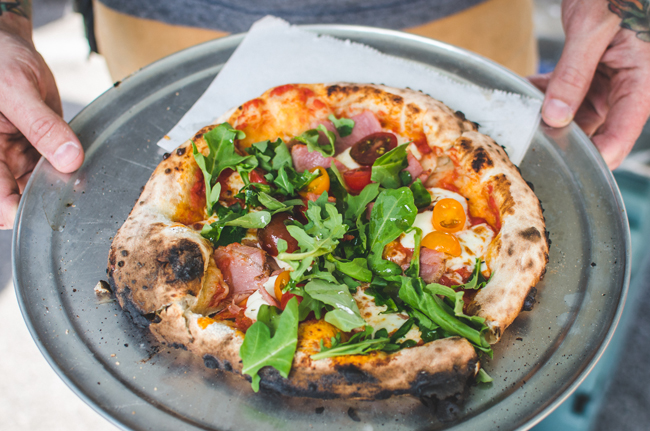 A King Dough pizza with arugula, herbs, and fresh tomato. Photo by Aubrey Dunnuck