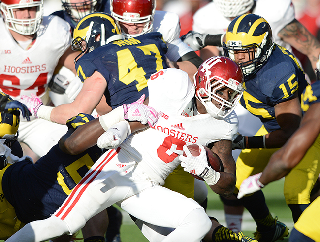 Indiana University running back Tevin Coleman is swarmed by Michigan tacklers in a 2014 game at Michigan Stadium. An All-American, Coleman finished seventh in the Heisman Trophy voting but wasn’t drafted by the NFL until the third round, the 73rd player overall. Photo by Mike Dickbernd/IU Athletics