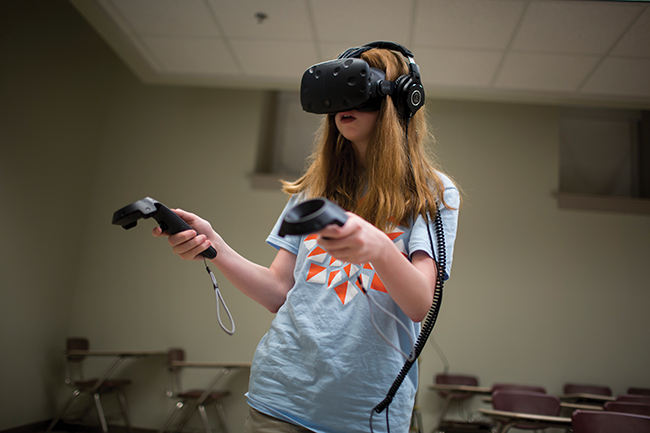  Maddie Pasquale, 14, uses a virtual reality headset during GirlPowered! Photo by James Brosher, IU Communications