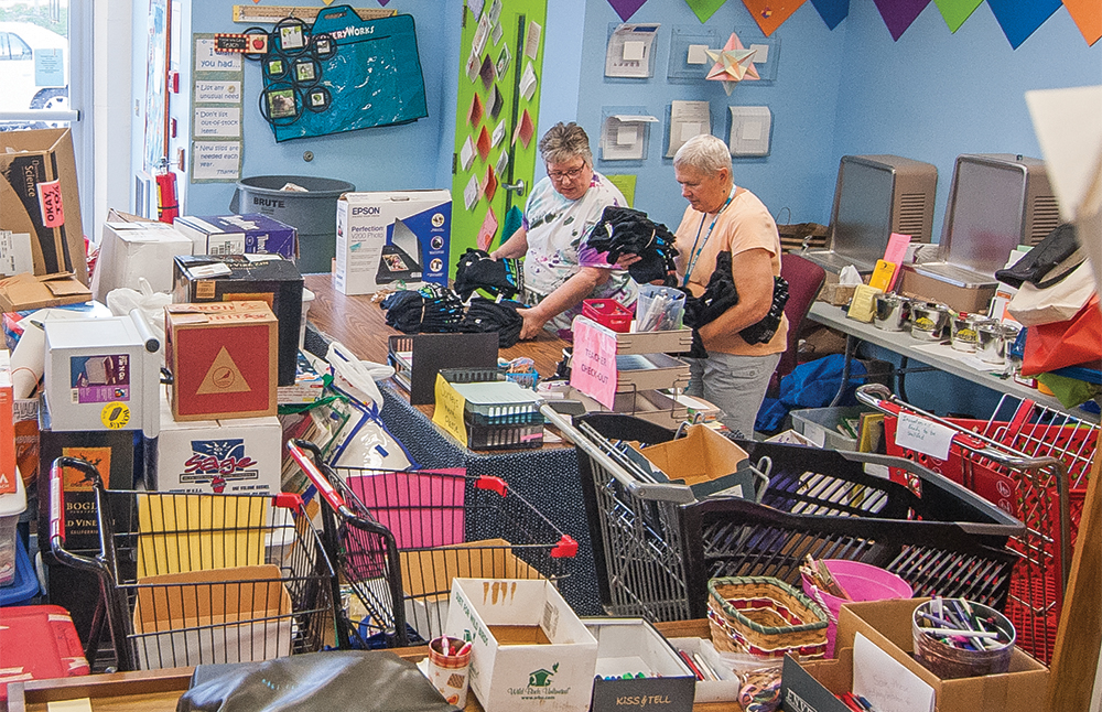 Volunteers help sort classroom supplies at Teachers Warehouse. Photo by Rodney Margison