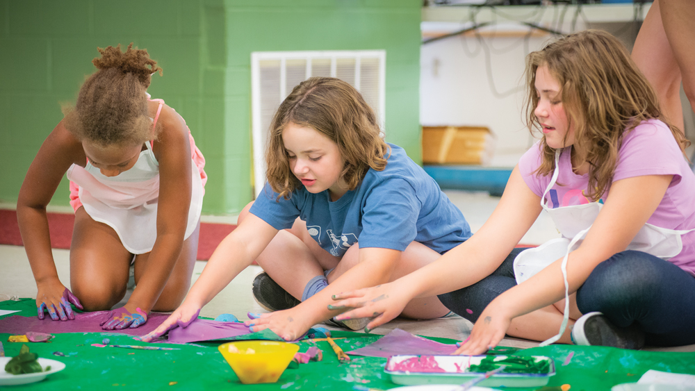 Jordan, 8, Story, 8, and Alexis, 10, participate in the Painting with Fruits and Vegetables activity during the Girls Inc. summer camp in June. Photos by Rodney Margison