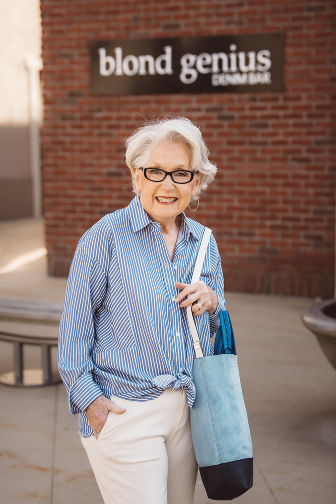 Karen Hicks wears a striped cotton blouse from Vince that coordinates with a Rag & Bone convertible leather and suede tote. Pants by AG Jeans, sunglasses by Tom Ford, and earrings by Gorjana.