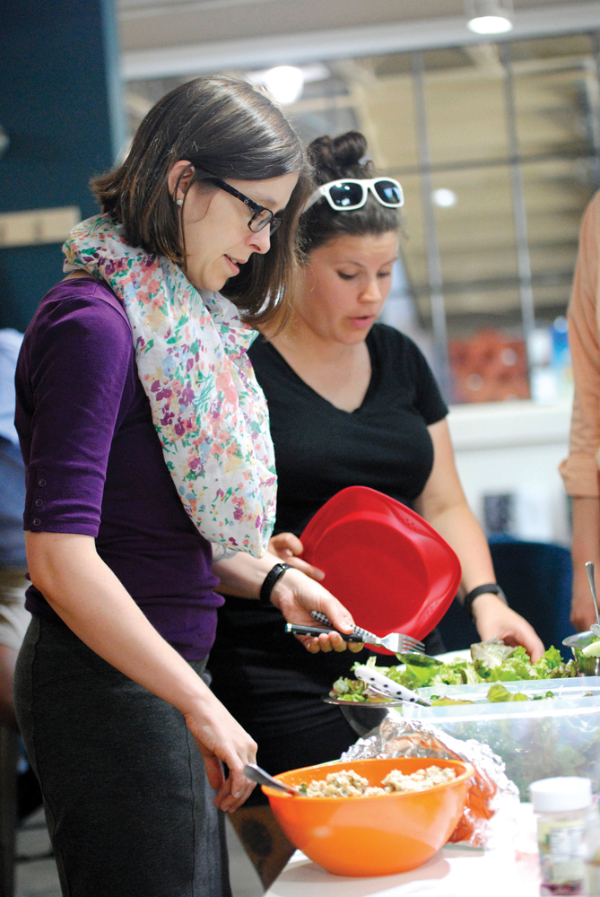 Event organizer, Jessika Griffin and BloomingVeg founder Kirstin Milks, help themselves to plates of salad during the 5th Anniversary of BloomingVeg.