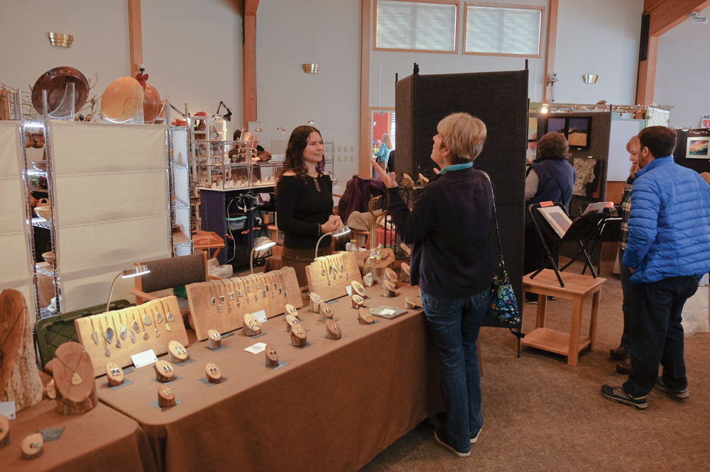 Shoppers look over jewelry, artwork, and knitted hats and scarves at previous Holiday Art Fair and Bazaar events held at the Unitarian Universalist Church of Bloomington. Photos by John Woodcock