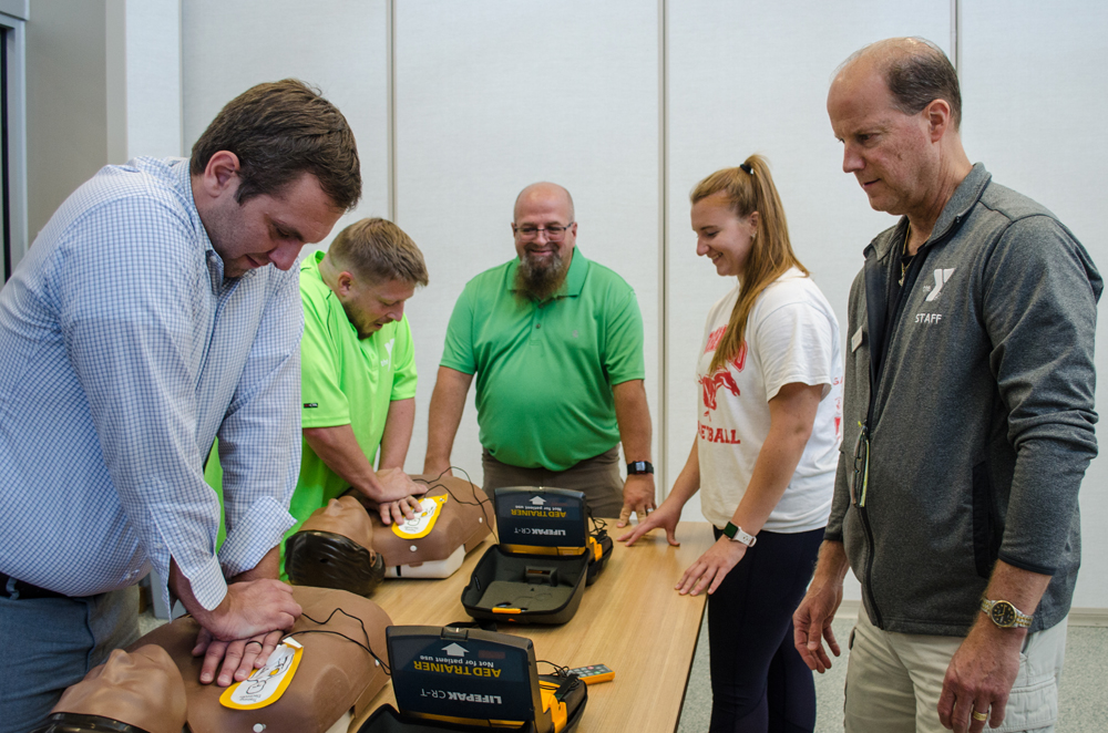 Kevin Vail, Chris Stone, CPR/AED instructor Kraig Bushey, Brittany Crawford, and YMCA Risk Management Coordinator Kevin Thompson demonstrate CPR. Photos by Mike Waddell