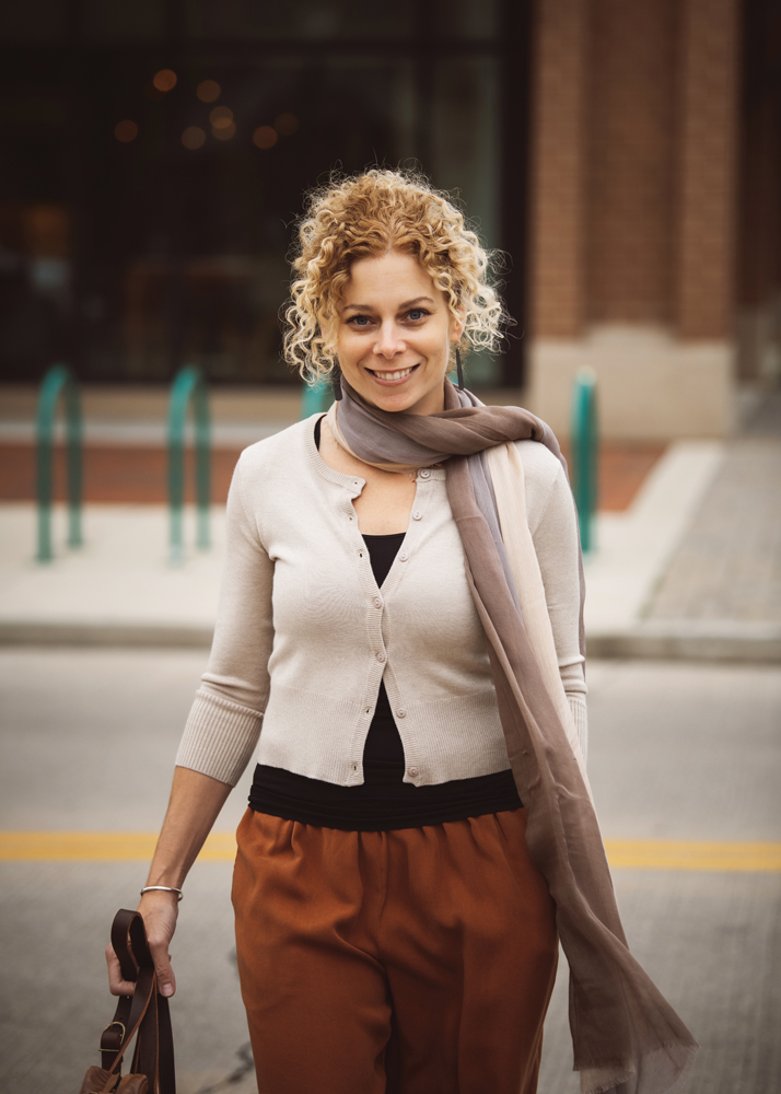 Samantha Eibling’s ensemble features a beige cropped cardigan by Survival layered over a black tank top from Last Tango, Cut Loose pants in rust, and a silk and cashmere scarf by Blue Pacific.