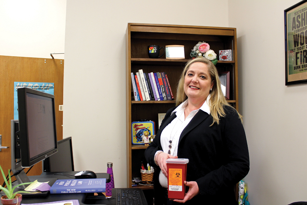 Carrie Ann Lawrence holds a sharp disposal container in her office at Indiana University’s Sycamore Hall. Lawrence’s program, Project Cultivate, helps to slow the spread of Hep. C by increasing response to injected drugs use. Photo by Nicole McPheeters