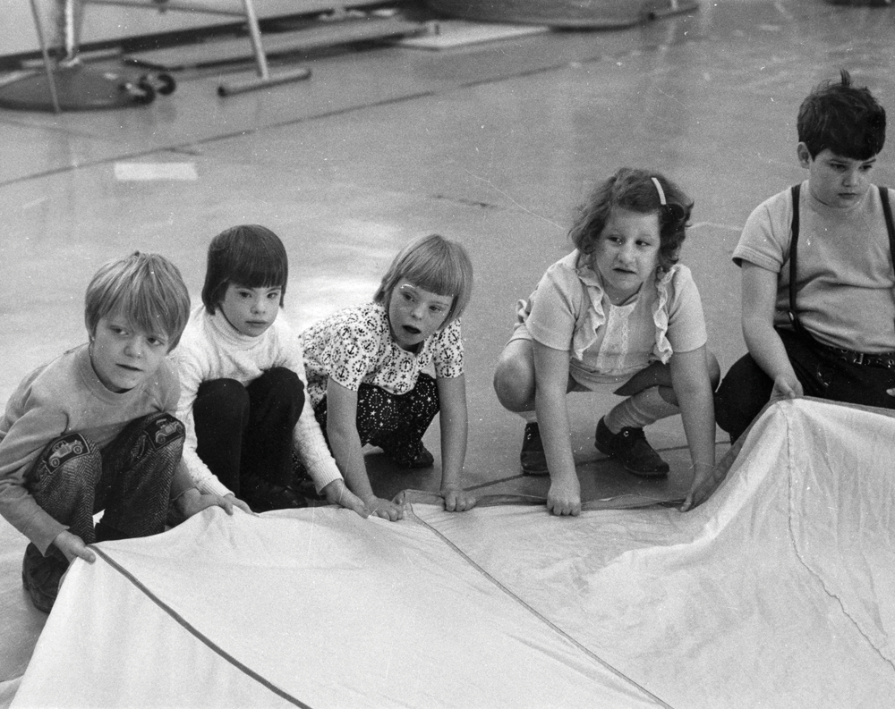 Students play with a parachute in the early 1960s. Phyllis Gibbs, third from left, is a Stone Belt client still today.