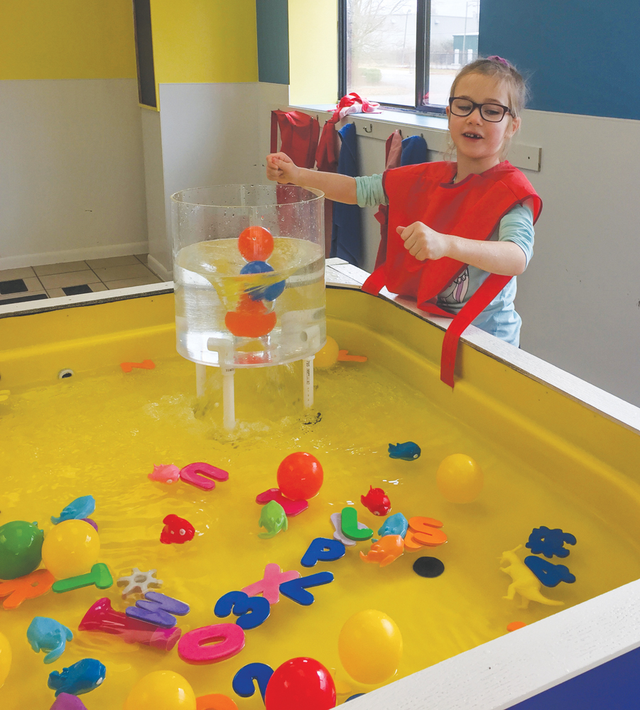 Cora Mansfield plays with the water table vortex tornado at Kids Play Gym. Photo by Carmen Siering